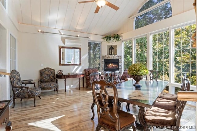 sunroom / solarium featuring ceiling fan, wooden ceiling, a wall mounted AC, lofted ceiling, and a fireplace