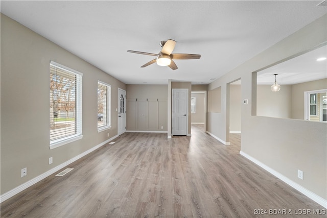 unfurnished room with light wood-type flooring and ceiling fan