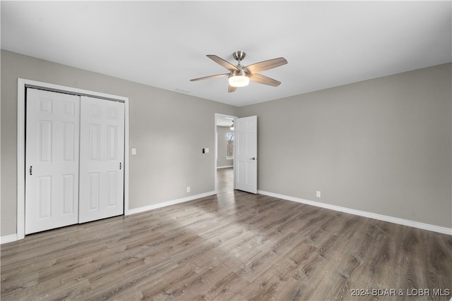 unfurnished bedroom featuring a closet, ceiling fan, and hardwood / wood-style floors