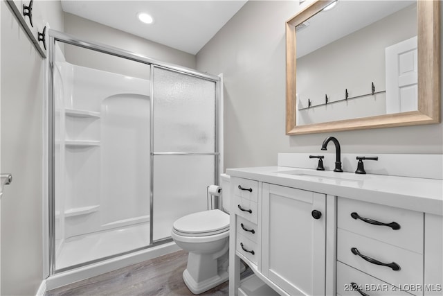 bathroom with walk in shower, toilet, vanity, and hardwood / wood-style flooring