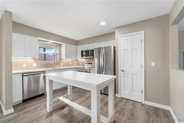 kitchen featuring sink, white cabinets, light hardwood / wood-style floors, and appliances with stainless steel finishes