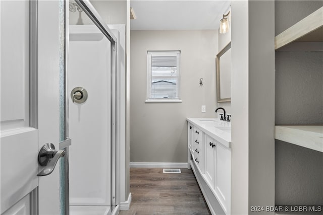 bathroom with vanity, wood-type flooring, and a shower with shower door