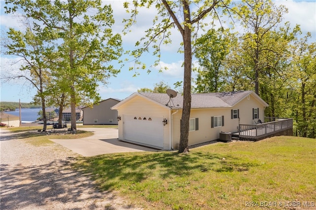 view of side of property with a garage, a deck, a yard, and central air condition unit