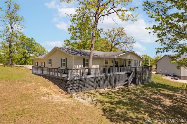 back of property featuring a deck and a lawn