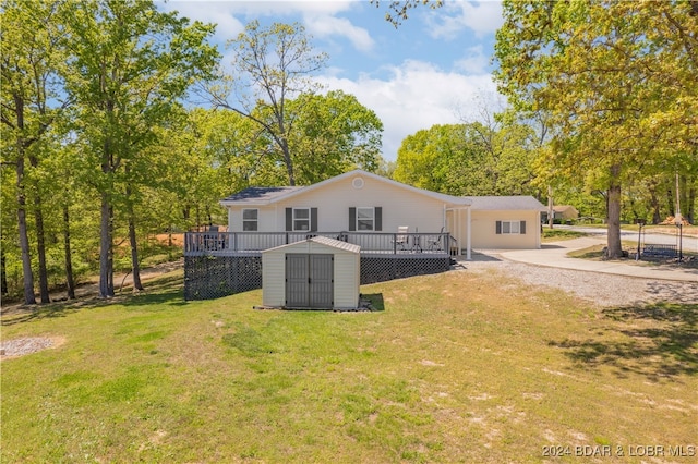 rear view of house featuring a shed, a deck, and a yard