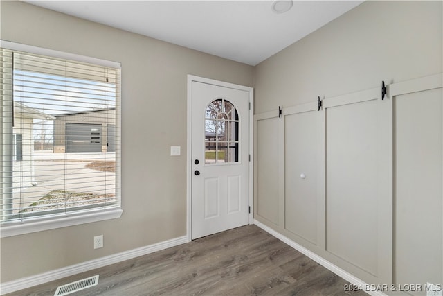 foyer featuring wood-type flooring and a barn door