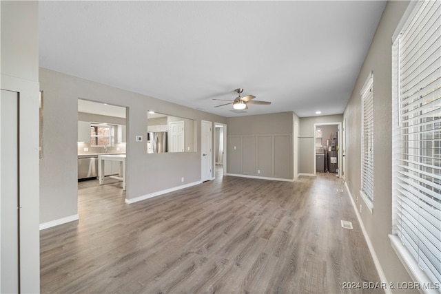 unfurnished living room featuring ceiling fan and light hardwood / wood-style flooring