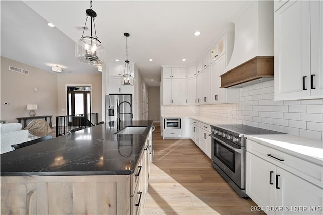 kitchen with a spacious island, white cabinetry, stainless steel appliances, and custom exhaust hood