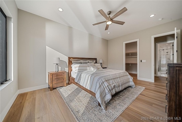 bedroom with a closet, a spacious closet, ceiling fan, and light hardwood / wood-style flooring