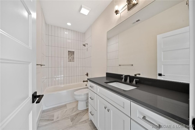 full bathroom with vanity, tiled shower / bath combo, and toilet