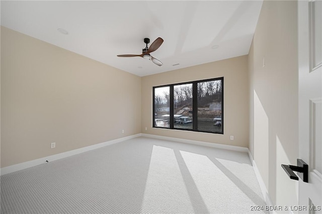 carpeted spare room with ceiling fan