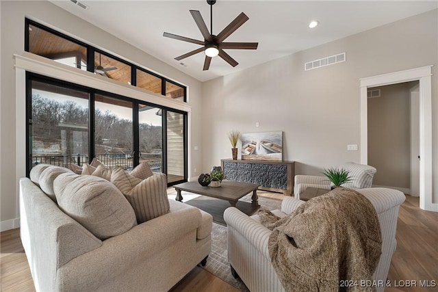 living room featuring hardwood / wood-style flooring, vaulted ceiling, and ceiling fan