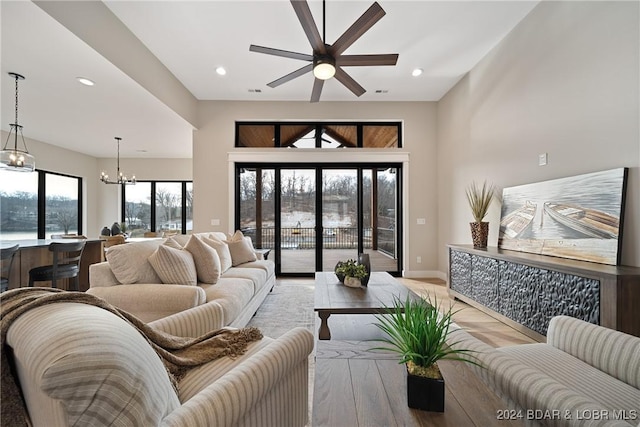 living room with ceiling fan with notable chandelier