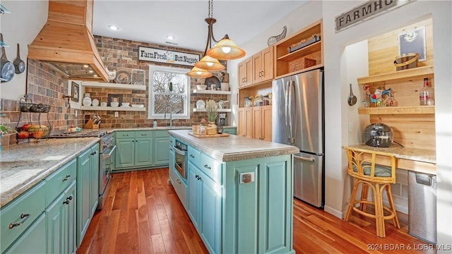 kitchen featuring premium range hood, sink, hardwood / wood-style flooring, a center island, and stainless steel appliances