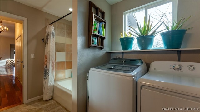 laundry room with an inviting chandelier and separate washer and dryer