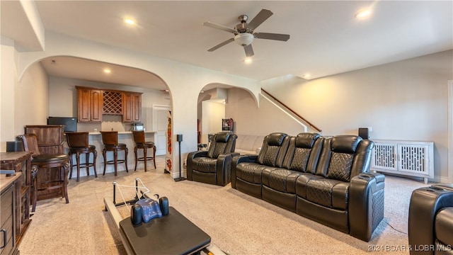 carpeted cinema featuring bar and ceiling fan