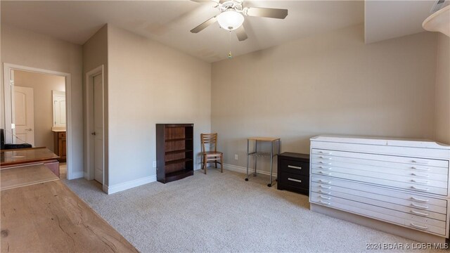 interior space featuring ceiling fan, light carpet, and connected bathroom