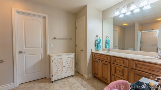 bathroom with tile patterned floors, a shower with door, vanity, and toilet