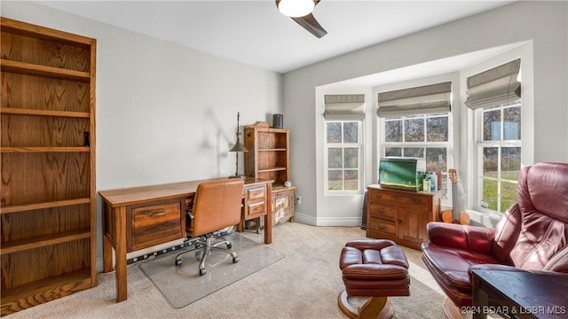 carpeted home office with ceiling fan and a healthy amount of sunlight