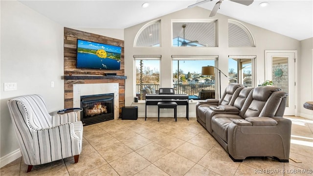 tiled living room featuring a tile fireplace, high vaulted ceiling, and ceiling fan