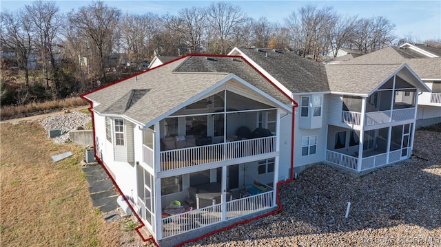 rear view of house with a sunroom and central AC