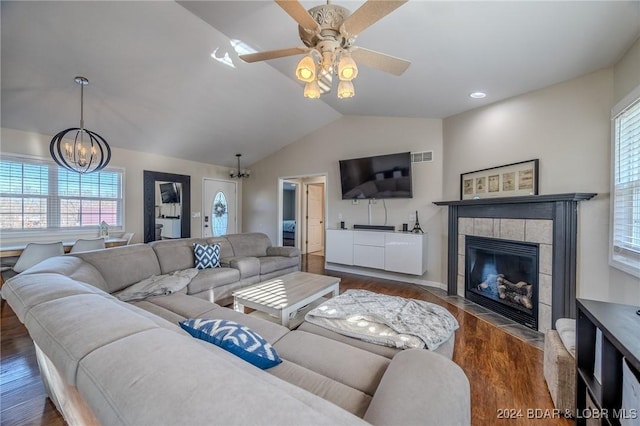 living room with lofted ceiling, a wealth of natural light, and dark hardwood / wood-style floors