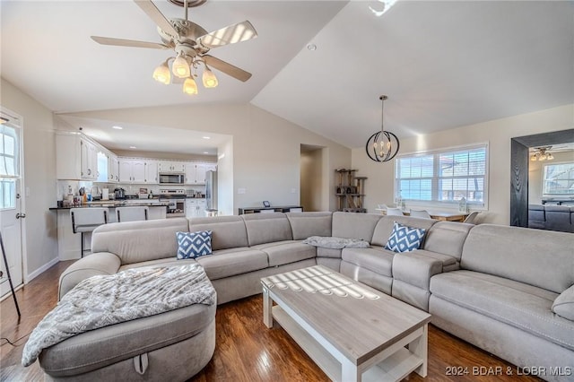 living room with sink, ceiling fan with notable chandelier, dark wood-type flooring, and lofted ceiling