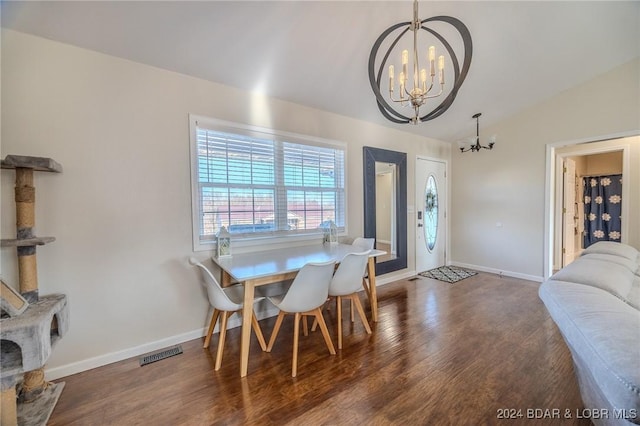 dining space with vaulted ceiling, a chandelier, and dark hardwood / wood-style floors