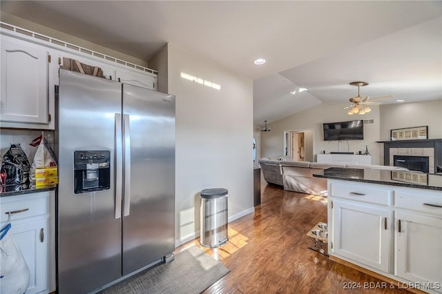 kitchen featuring ceiling fan, stainless steel refrigerator with ice dispenser, wood-type flooring, vaulted ceiling, and white cabinets