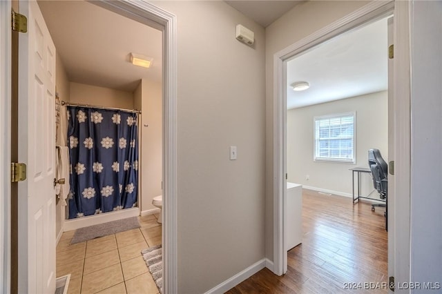 bathroom featuring hardwood / wood-style flooring, curtained shower, and toilet