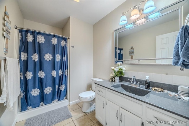 bathroom featuring tile patterned flooring, vanity, toilet, and walk in shower