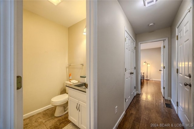 bathroom featuring vanity, toilet, and wood-type flooring