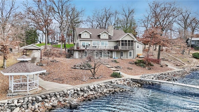 back of property featuring a gazebo and a water view