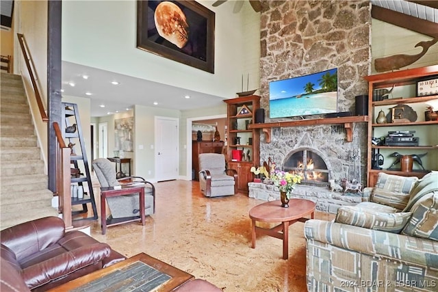 living room featuring a stone fireplace and a towering ceiling