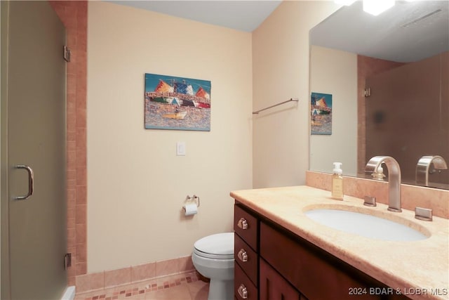 bathroom featuring a shower with door, vanity, tile patterned flooring, and toilet