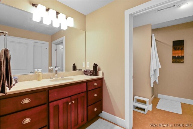 bathroom with tile patterned flooring, vanity, and a shower with shower door