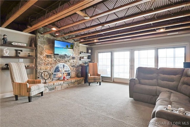 carpeted living room featuring beamed ceiling and a fireplace