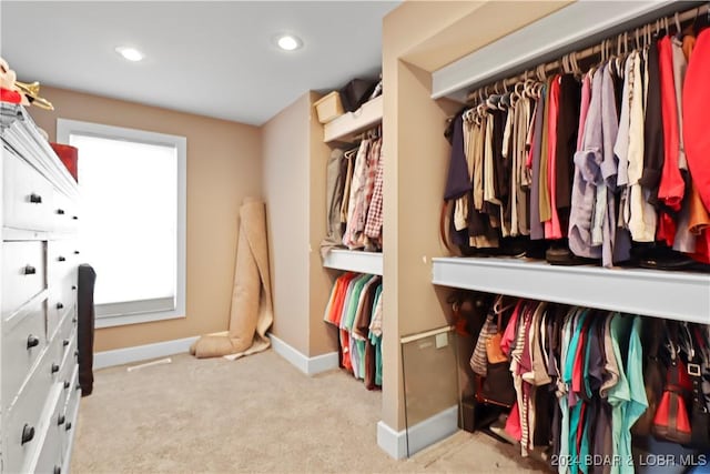 walk in closet featuring light colored carpet