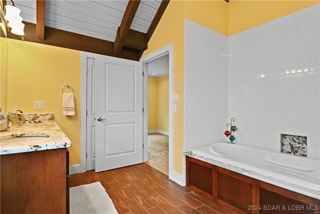 bathroom with wood ceiling, vanity, wood-type flooring, vaulted ceiling with beams, and a bathing tub