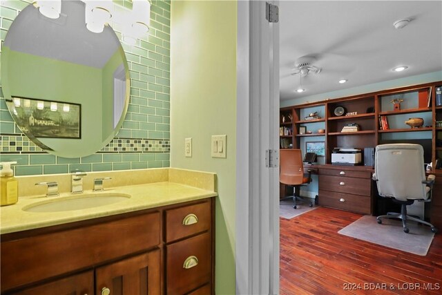 bathroom with vanity, wood-type flooring, backsplash, and ceiling fan