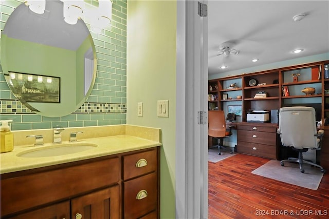 bathroom featuring vanity, decorative backsplash, wood-type flooring, and ceiling fan