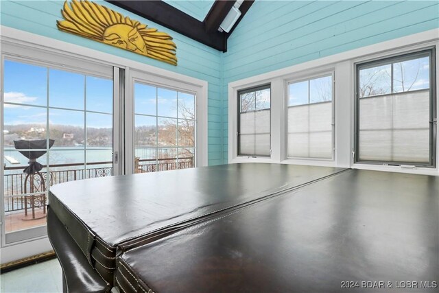 interior space featuring a water view, a healthy amount of sunlight, and lofted ceiling