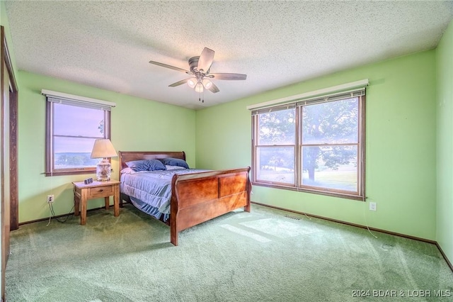 bedroom with light carpet, a textured ceiling, and ceiling fan