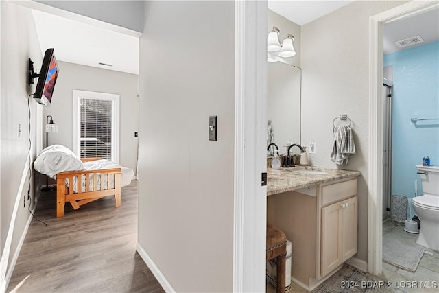 bathroom with vanity, wood-type flooring, and toilet