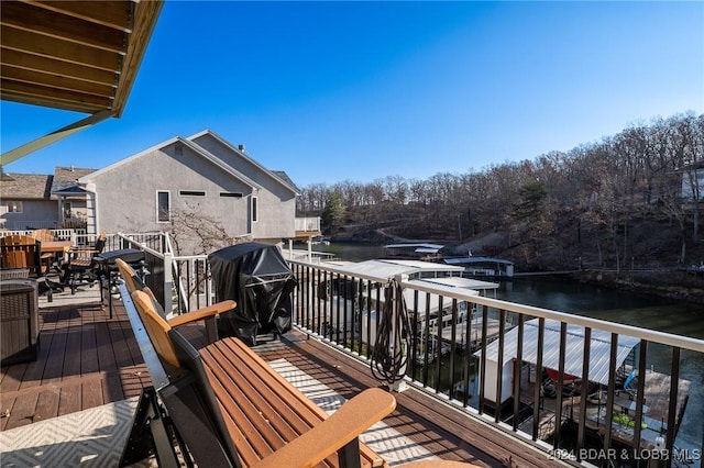 wooden terrace featuring a water view and area for grilling