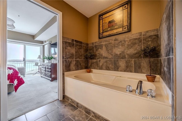 bathroom with tile patterned flooring and a bath