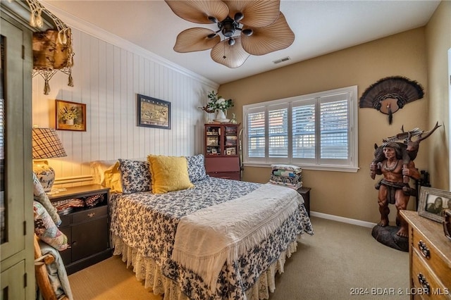 bedroom with ceiling fan, ornamental molding, and light carpet