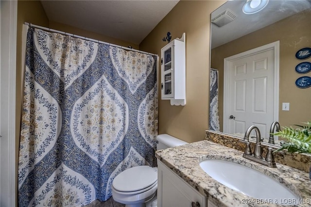 bathroom with vanity, toilet, and a textured ceiling