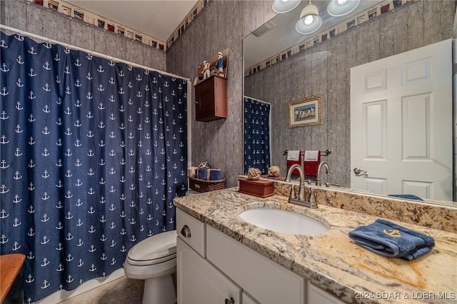 bathroom with tile patterned floors, walk in shower, vanity, and toilet