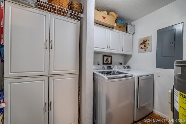 clothes washing area featuring washer and clothes dryer, cabinets, a textured ceiling, and electric panel